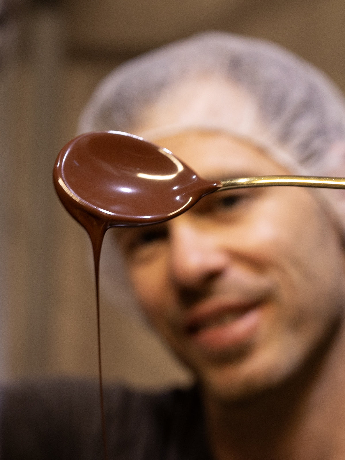 image of man drizzling chocolate from a spoon