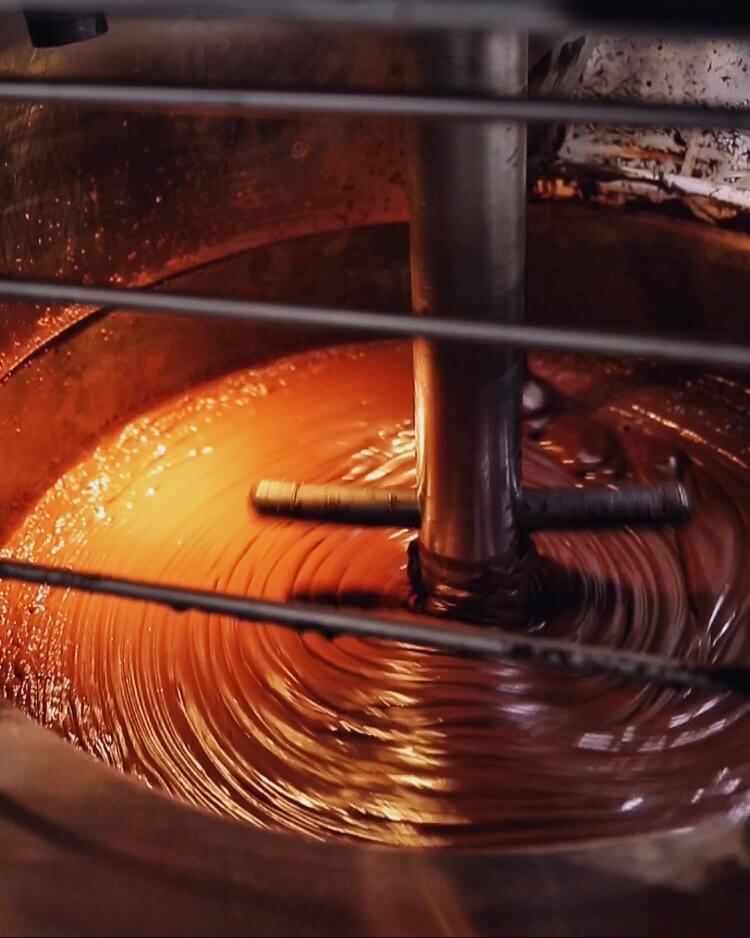 Image of liquid chocolate being stirred by industrial machine