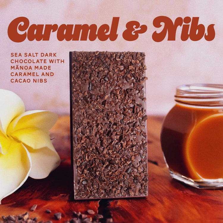 caramel and nibs chocolate bar on table with flower and jar of caramel