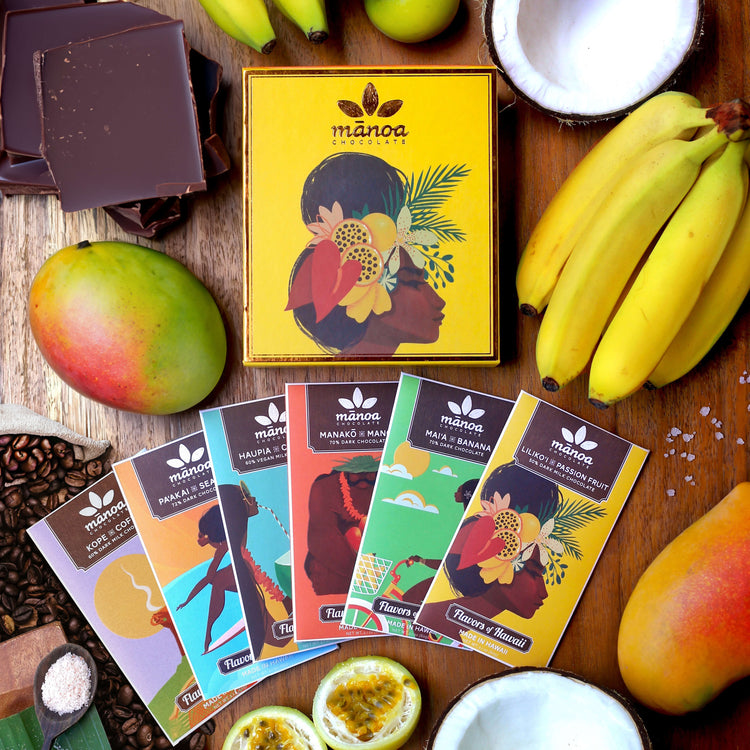 Image of six brightly-colored chocolate bars with bright yellow gift box and tropical fruits