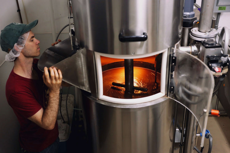 Image of man looking into industrial machine grinding chocolate