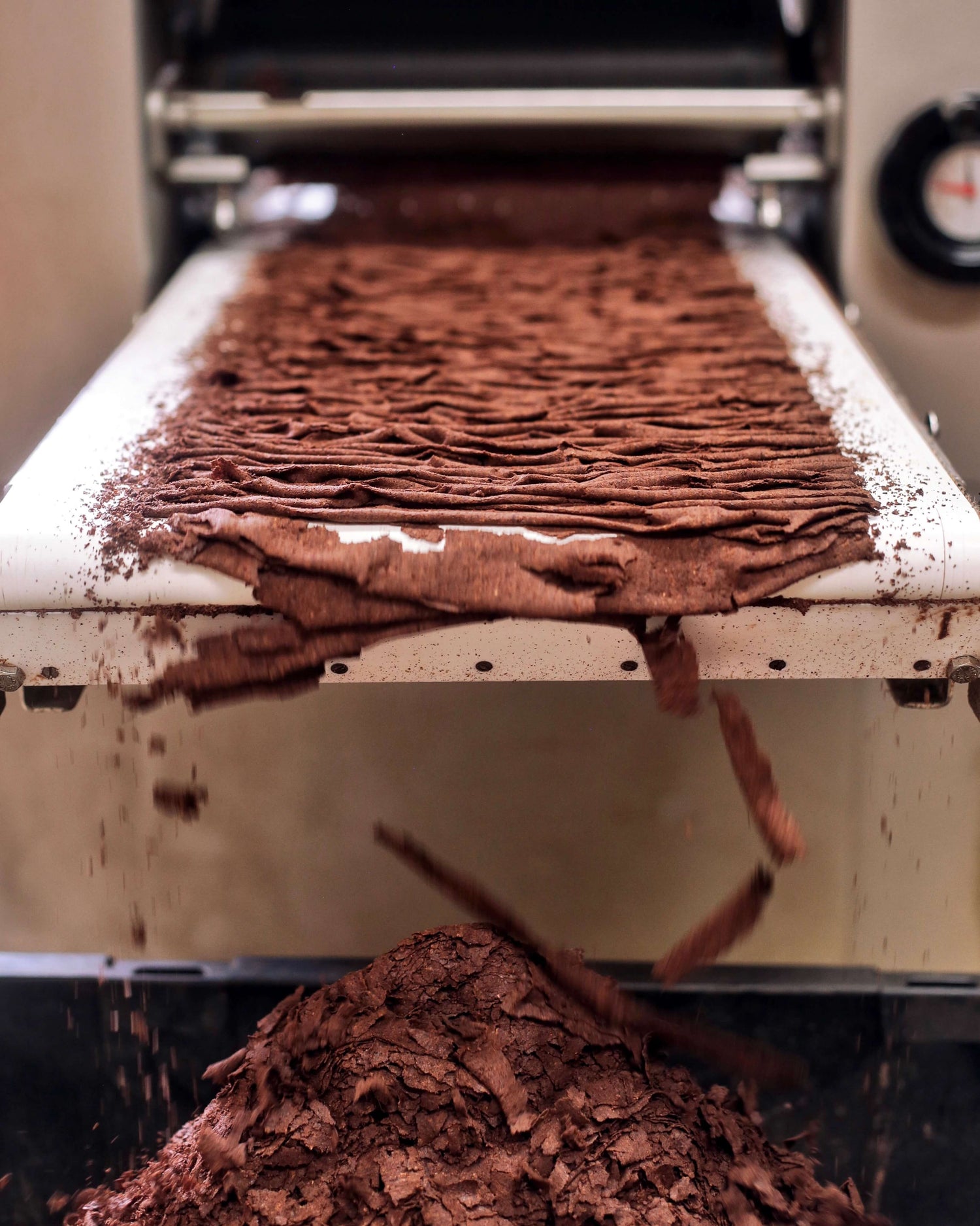Image of machine crushing cacao nibs into a fine powder