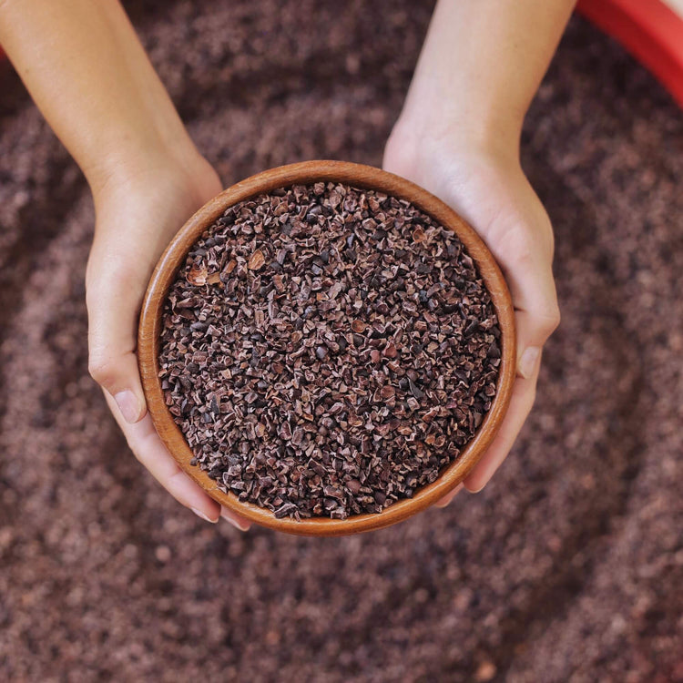 Image of person holding bowl of cacao nibs