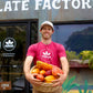 Image of man holding basket of cacao pods in front of Manoa storefront