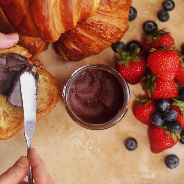 Image of person spreading chocolate macadamia spread on toast