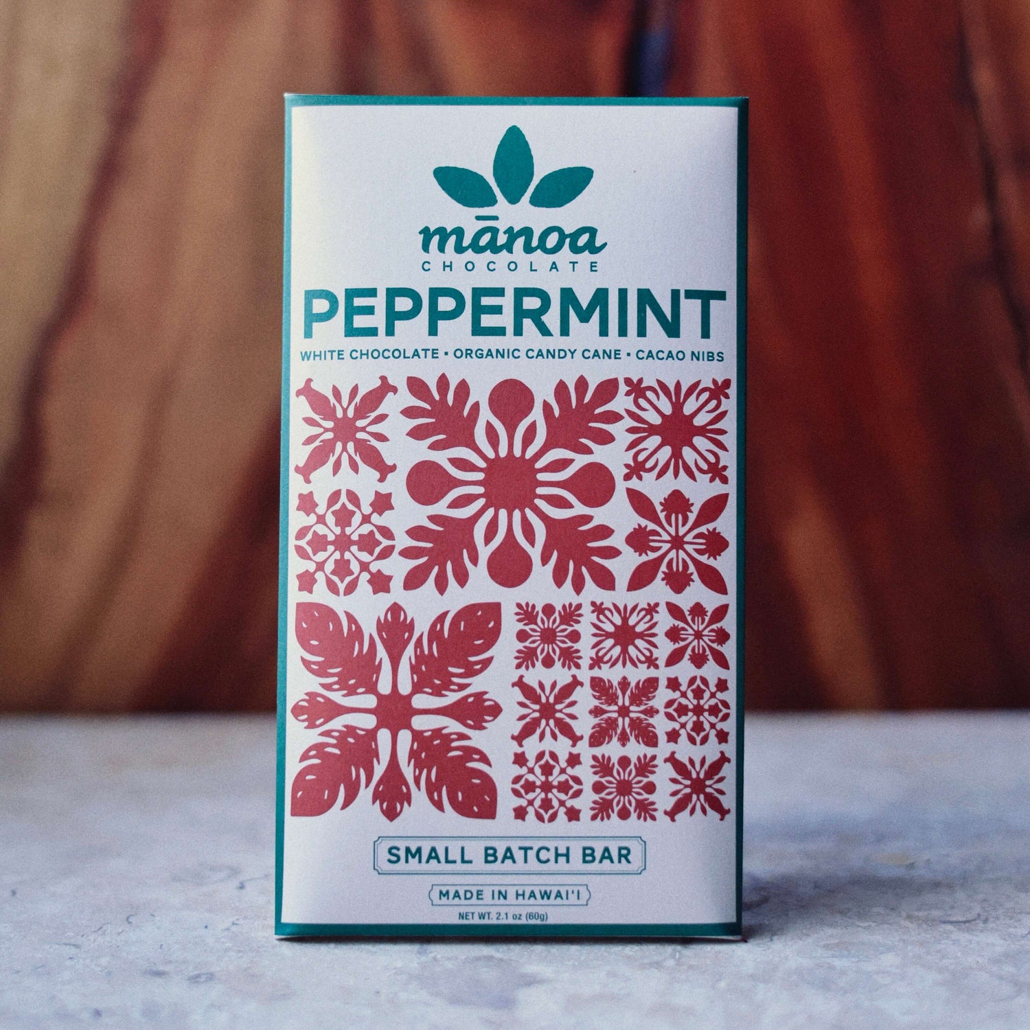 image of Manoa Chocolate peppermint crunch bar packaging with decorative design on a wooden surface