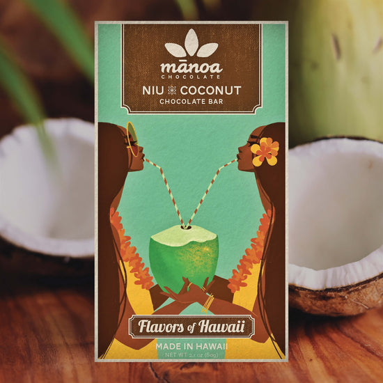 Image of Niu coconut chocolate bar in light blue packaging, sitting among sliced coconuts