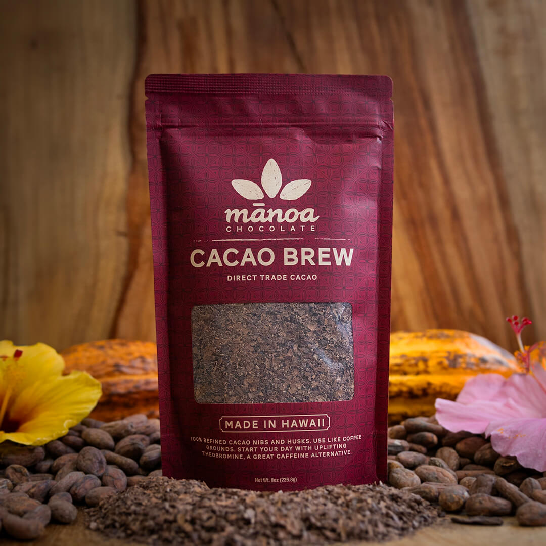 8oz bag of Cacao Brew with cacao brew, cacao beans, tropical flowers and cacao pods on a wooden table