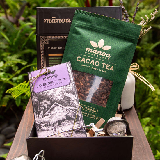 Image of open gift box with lavender latte chocolate bar, cacao tea pouch and tea infuser