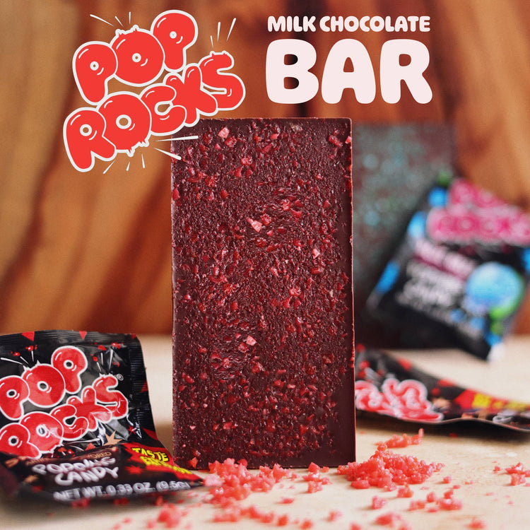 Image of pop rocks chocolate bar on table with pop rocks packets and pop rocks logo