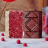 raspberry white and dark chocolate bars on a marble counter with raspberries and flower