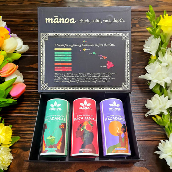 Image of coconut, guava, and coffee macadamia nut tubes with black and gold manoa-branded treasure box