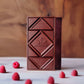 dark raspberry chocolate bars on a marble surface with raspberries