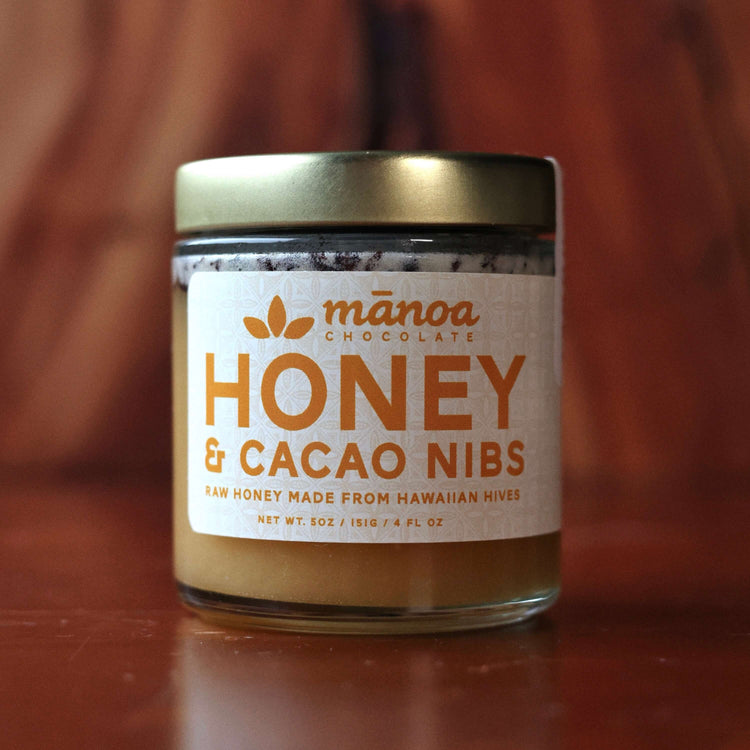 Jar of Manoa Chocolate Honey & Cacao Nibs on a wooden surface
