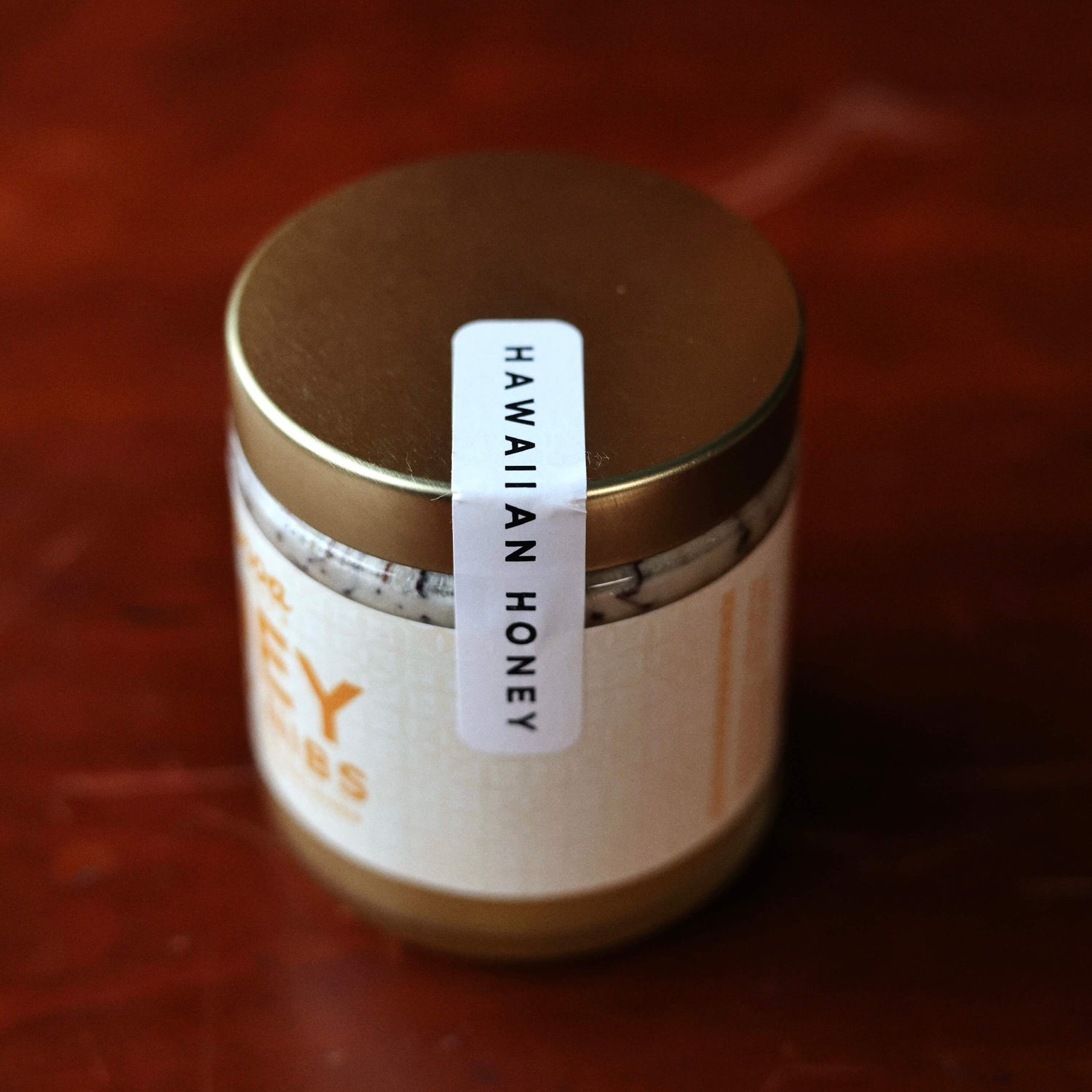 Jar of Hawaiian honey with a label on a red background