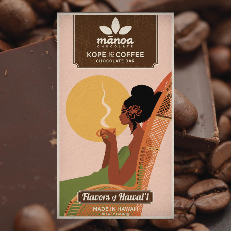 Image of Kope coffee bar, in light pink packaging, sitting among coffee beans