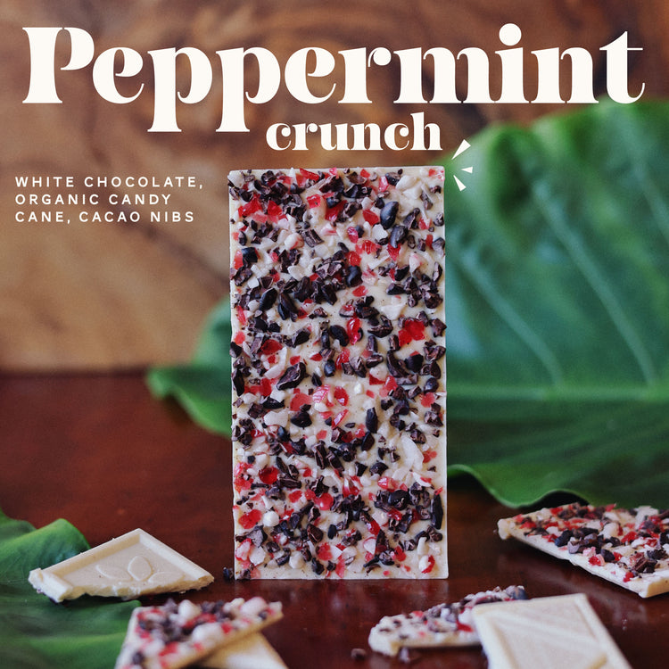 Peppermint Crunch - white chocolate, organic candy cane, cacao nibs. Image of peppermint crunch chocolate bar on wood table. 