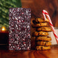 Image of Peppermint Crunch bar next to a candle, stack of cookies, and a candy cane
