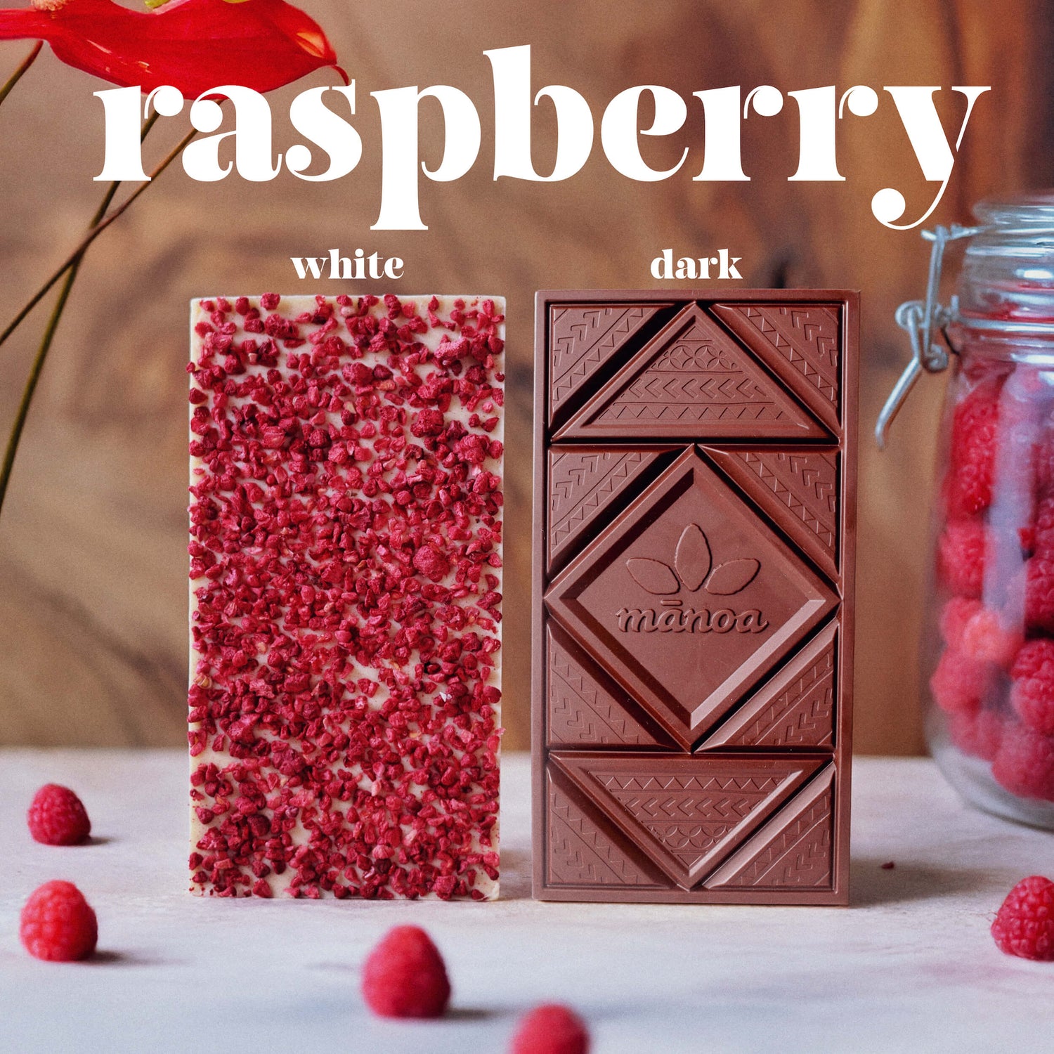raspberry white and dark chocolate bars on marble counter with raspberries and red flower
