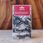 Manoa Chocolate White Raspberry white chocolate bar packaging on a wooden surface