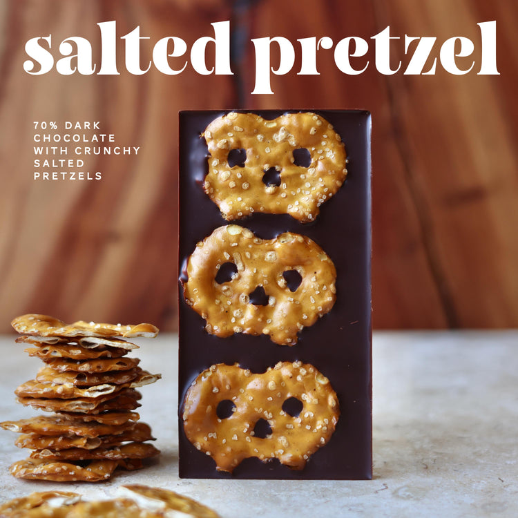 salted pretzel dark chocolate bar on a wood table with some pretzels on the side