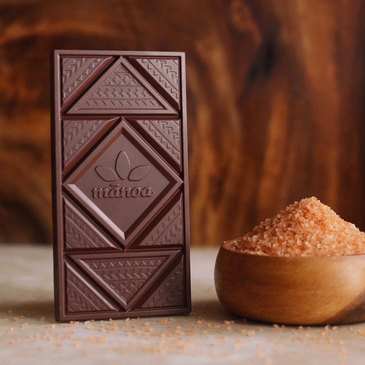 Image of a chocolate bar standing upright next to a bowl of pink salt