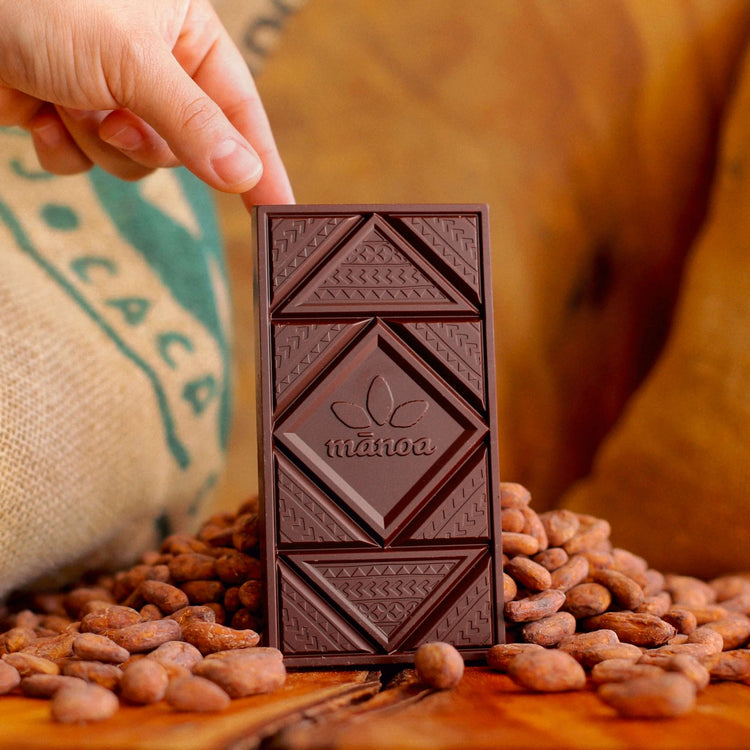 Image of a chocolate bar standing among cacao seeds