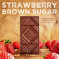 photo of strawberry brown sugar chocolate bar on wood table with strawberries and brown sugar. Text over image says "strawberry brown sugar - strawberry milk chocolate and brown sugar"