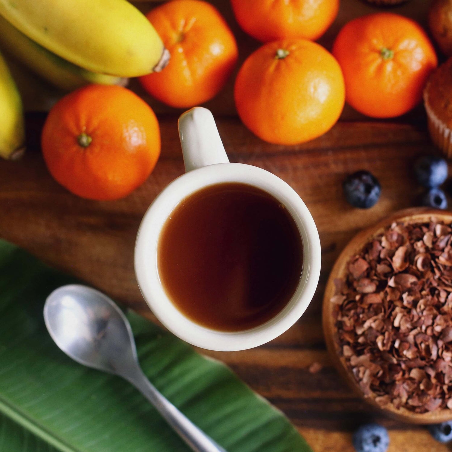 Image of a cup of cacao brew on table with mandarin oranges