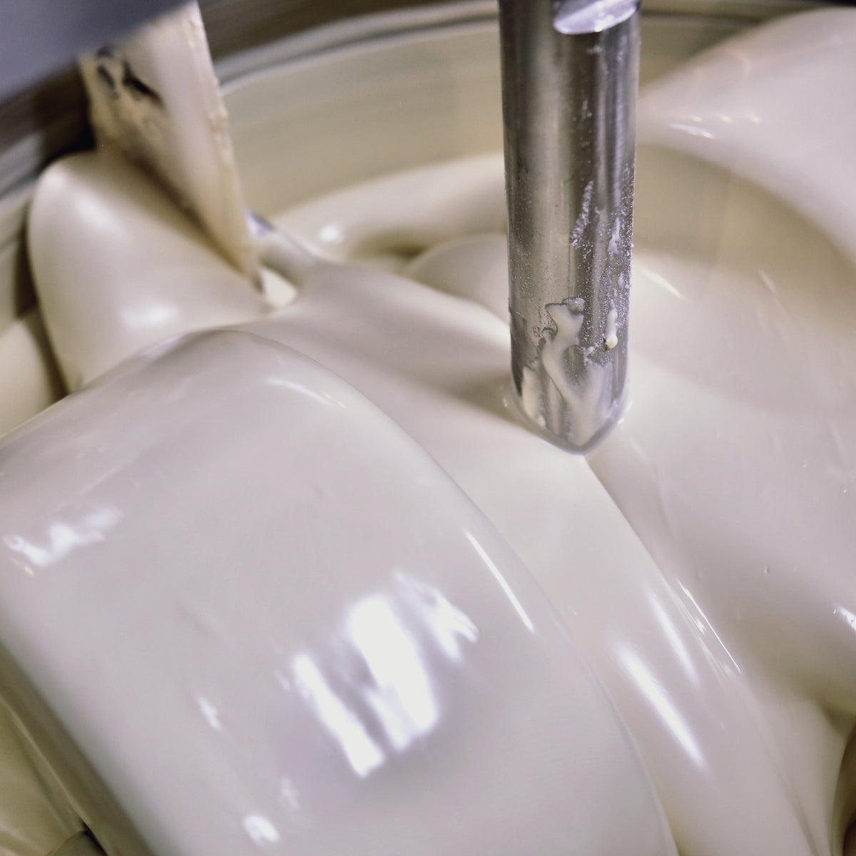 Image of liquid white chocolate in a stone grinder