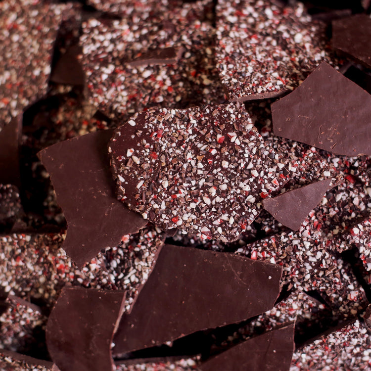 Image of dark chocolate peppermint bark, showing crushed candy cane and cacao nibs on the back