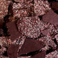 Image of dark chocolate peppermint bark, showing crushed candy cane and cacao nibs on the back