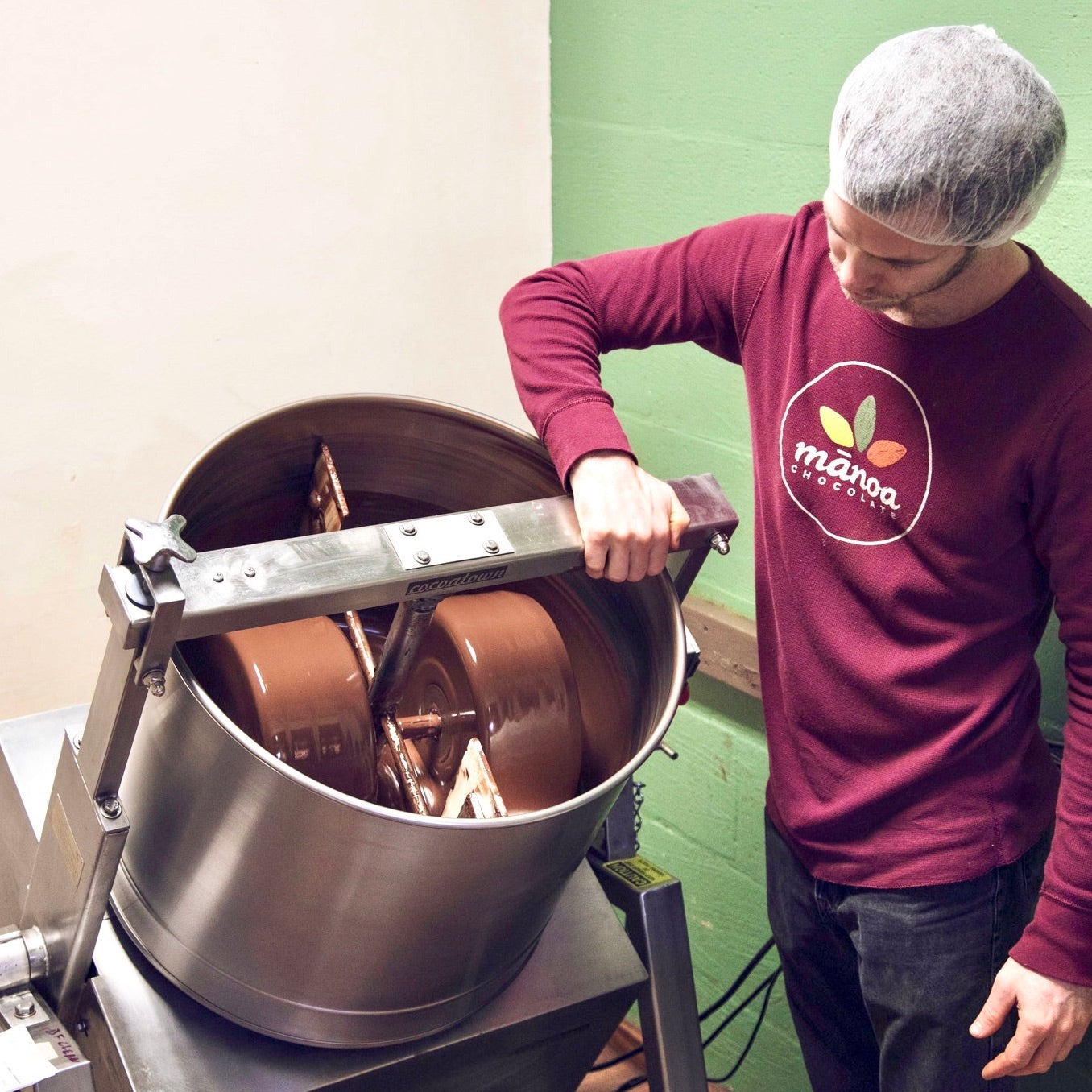 Man operating industrial chocolate-making equipment
