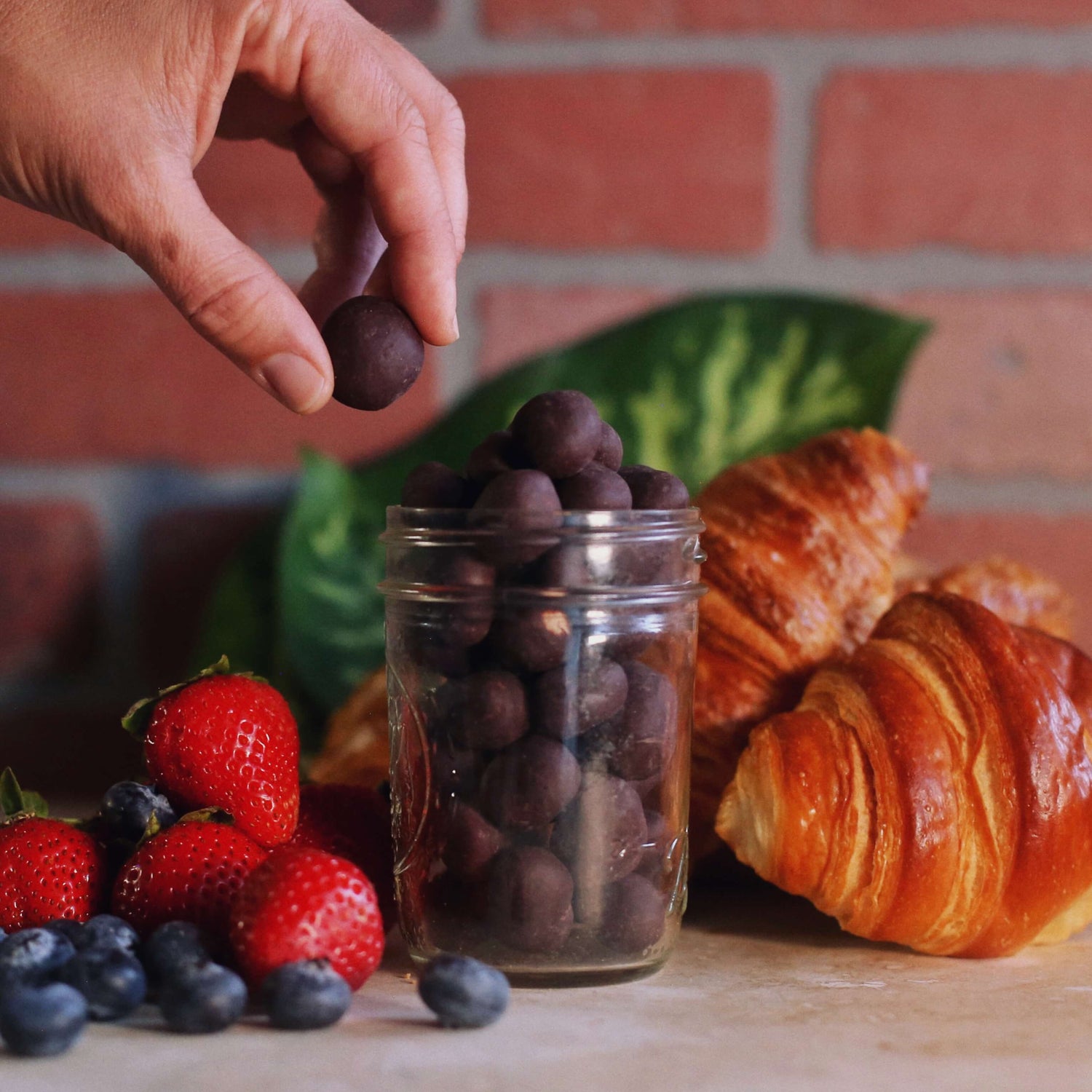 Image of person picking up dark chocolate hazelnut from jar