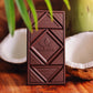 Image of chocolate bar sitting among sliced coconuts