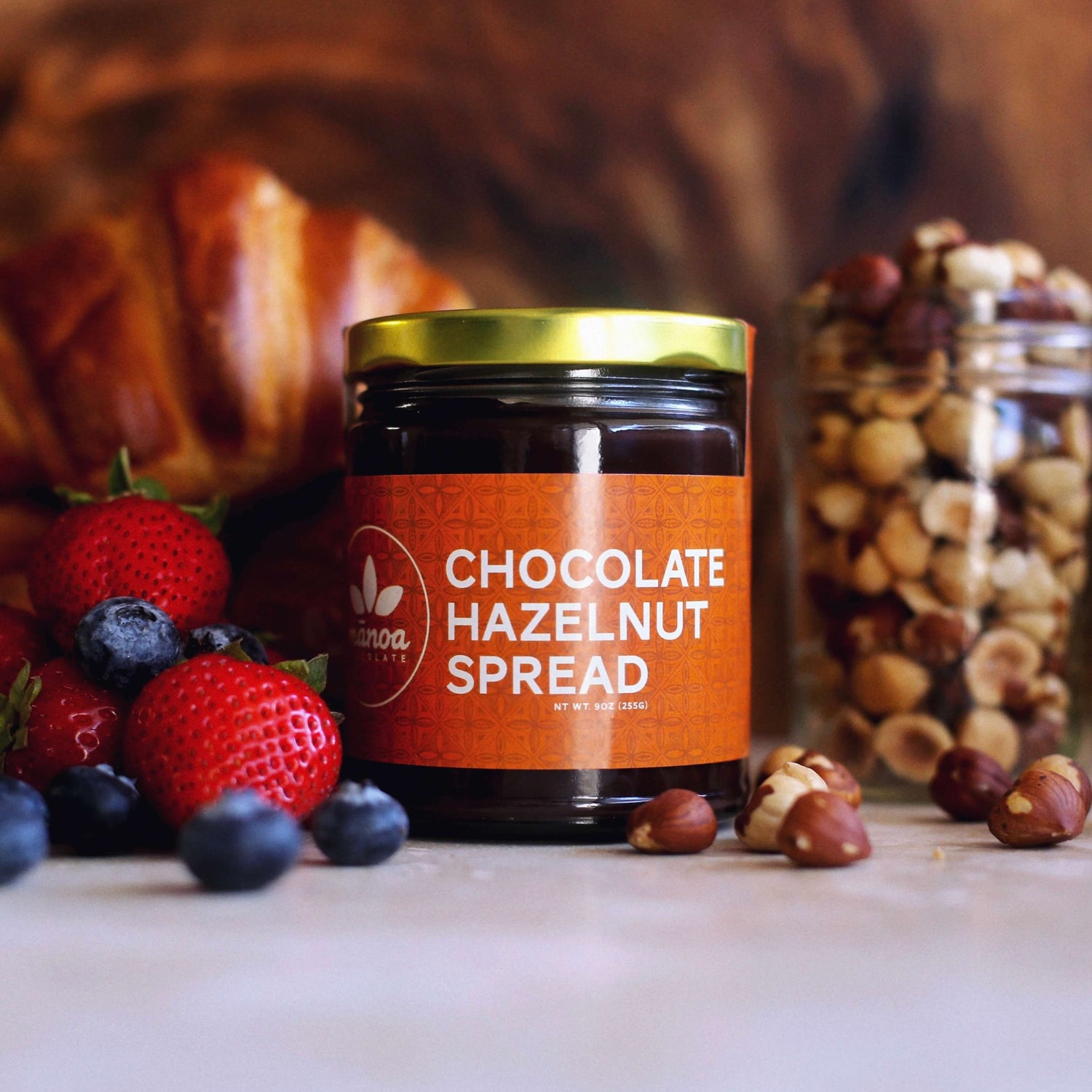 Jar of chocolate hazelnut spread among fruit and nuts